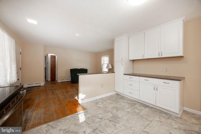 kitchen with electric stove, a baseboard radiator, and white cabinets