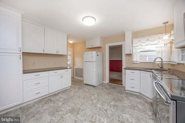 kitchen with white cabinetry, sink, stainless steel electric range oven, and white fridge