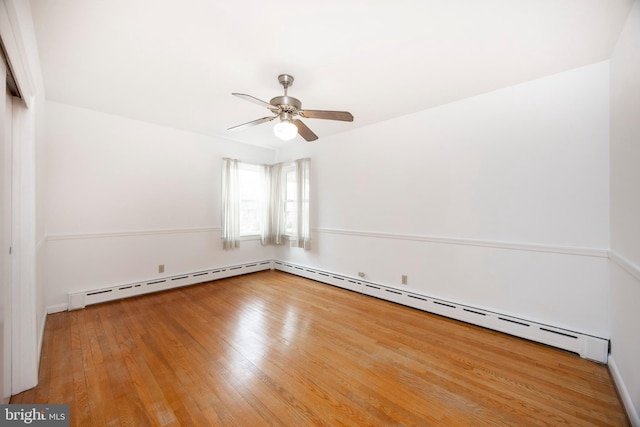 unfurnished room featuring wood-type flooring, a baseboard heating unit, and ceiling fan