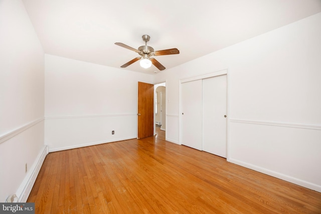 unfurnished bedroom with baseboard heating, a closet, ceiling fan, and light hardwood / wood-style flooring