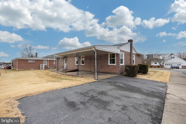 view of front of property with a carport and a front lawn