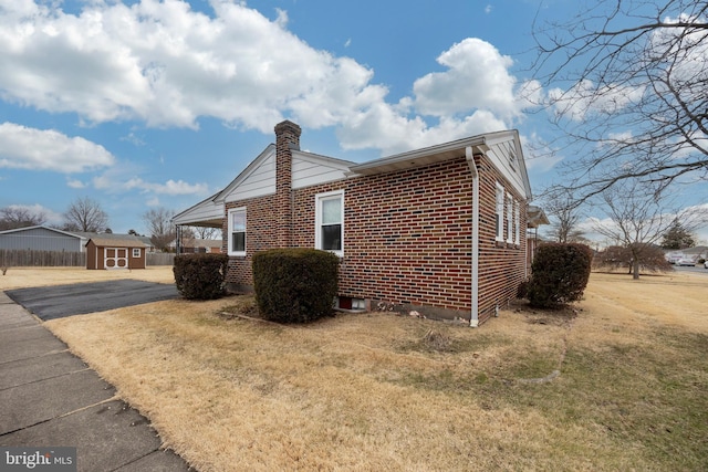 view of side of property featuring a yard and a shed