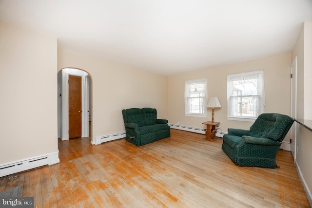 living area with light wood-type flooring and a baseboard heating unit