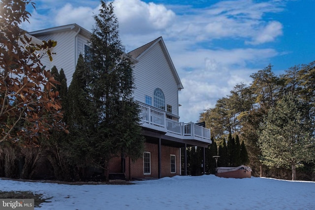 snow covered property featuring a hot tub and a wooden deck