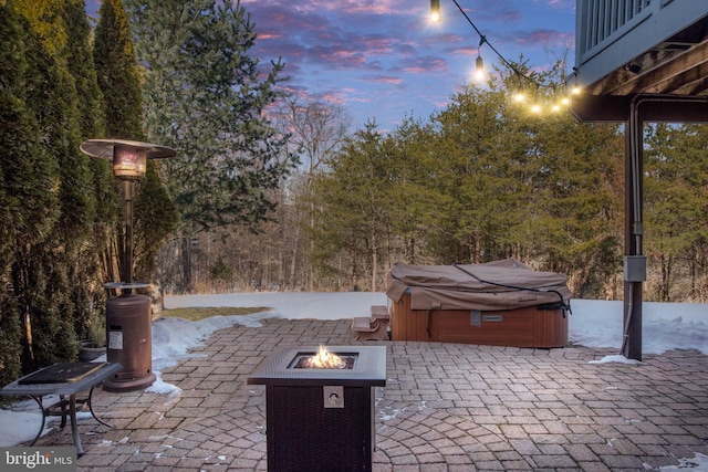 patio terrace at dusk with a fire pit and a hot tub