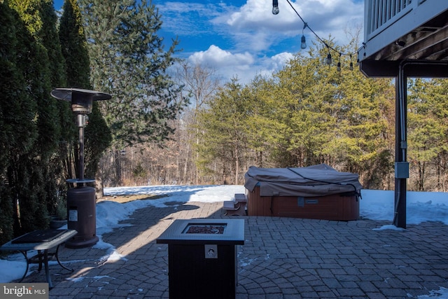 view of patio with a hot tub and a fire pit