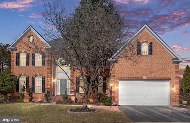 front facade featuring a garage and a yard