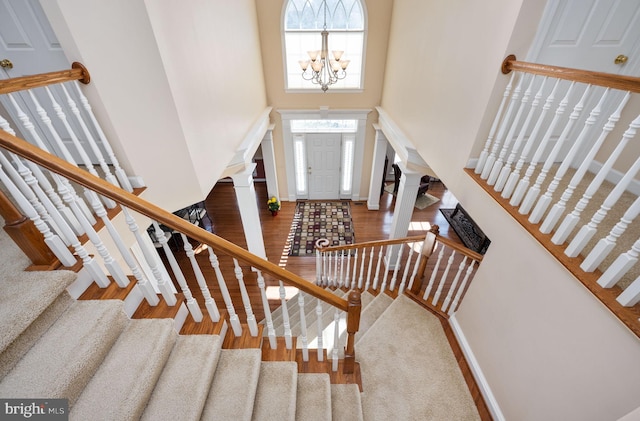 entryway featuring a towering ceiling, hardwood / wood-style floors, and a chandelier