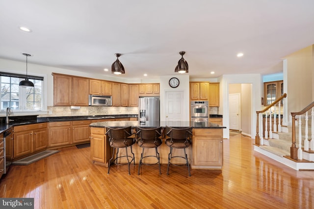 kitchen featuring tasteful backsplash, sink, stainless steel appliances, and a center island