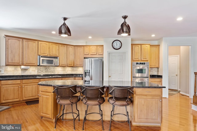 kitchen with hanging light fixtures, stainless steel appliances, and a center island