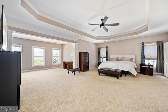 carpeted bedroom featuring crown molding, ceiling fan, a tray ceiling, and decorative columns