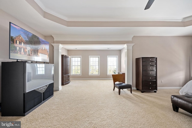 living area featuring a tray ceiling, a wealth of natural light, carpet, and ornate columns