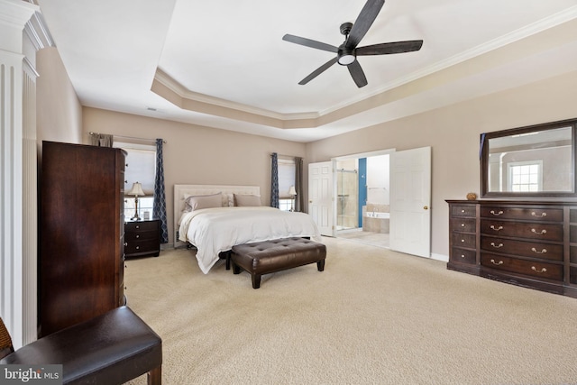 carpeted bedroom featuring a raised ceiling, ornamental molding, connected bathroom, and ceiling fan