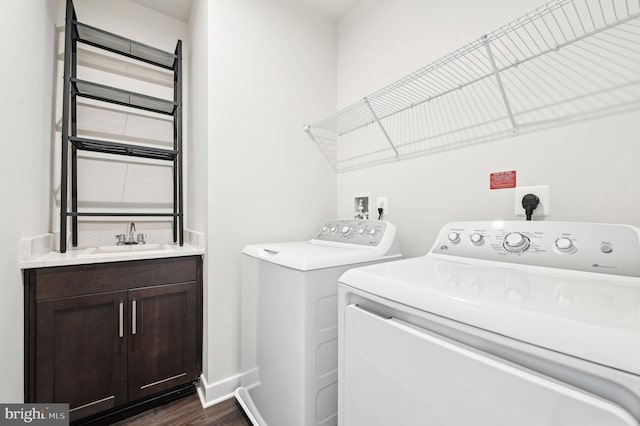 washroom with sink, cabinets, washer and clothes dryer, and dark hardwood / wood-style floors