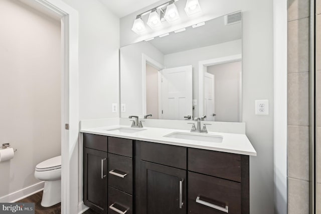 bathroom with toilet, wood-type flooring, and vanity