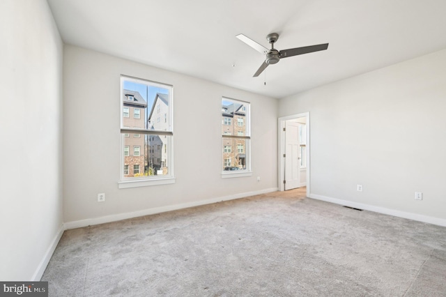 carpeted spare room with ceiling fan