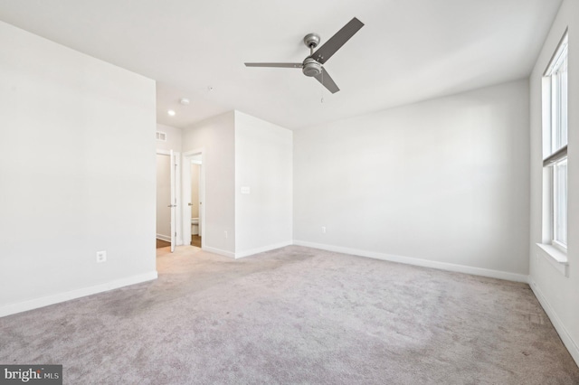 carpeted spare room featuring ceiling fan