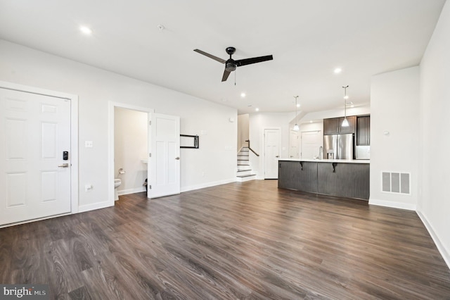 unfurnished living room featuring dark hardwood / wood-style flooring and ceiling fan