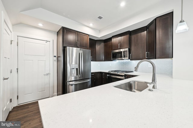 kitchen with sink, tasteful backsplash, stainless steel appliances, dark hardwood / wood-style flooring, and hanging light fixtures