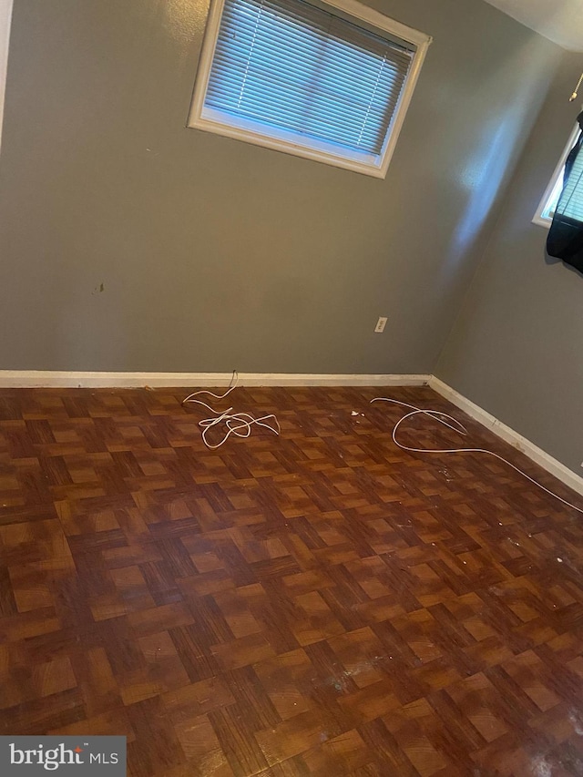 unfurnished room with dark parquet flooring