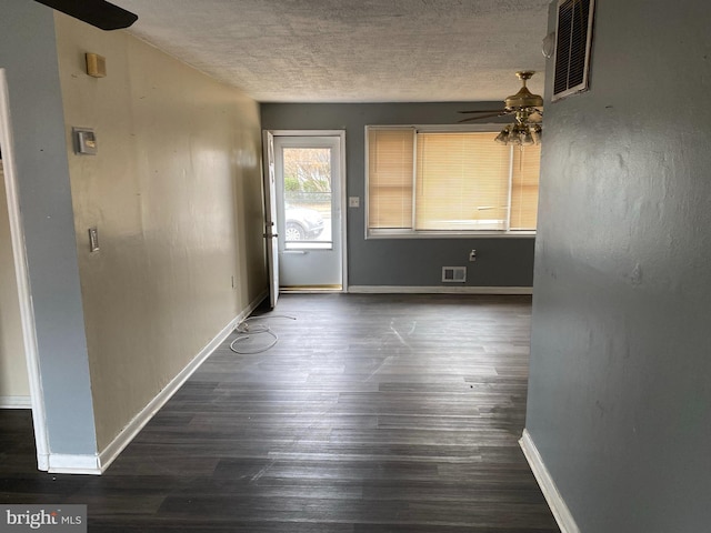 empty room featuring ceiling fan, dark hardwood / wood-style floors, and a textured ceiling