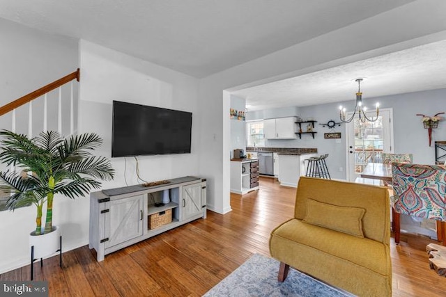 living room featuring an inviting chandelier and light wood-type flooring