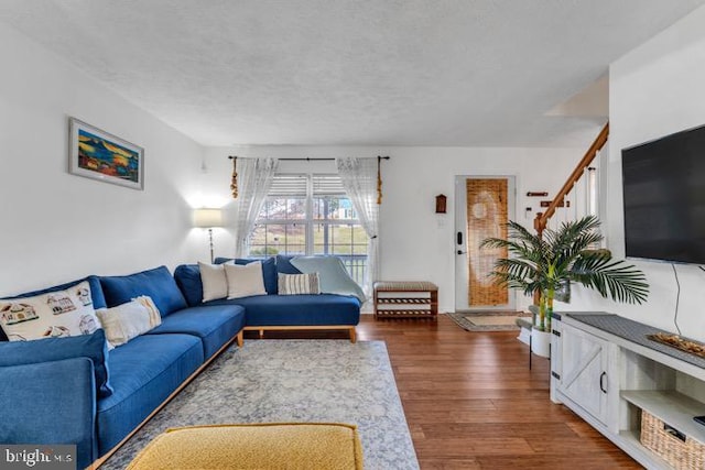 living room with dark hardwood / wood-style flooring and a textured ceiling