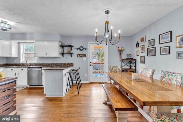 dining room with an inviting chandelier, sink, hardwood / wood-style floors, and a textured ceiling