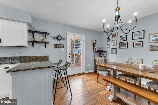 dining space with a textured ceiling and light wood-type flooring