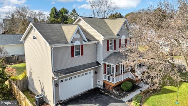 view of front of house featuring a garage, central AC unit, and a front yard