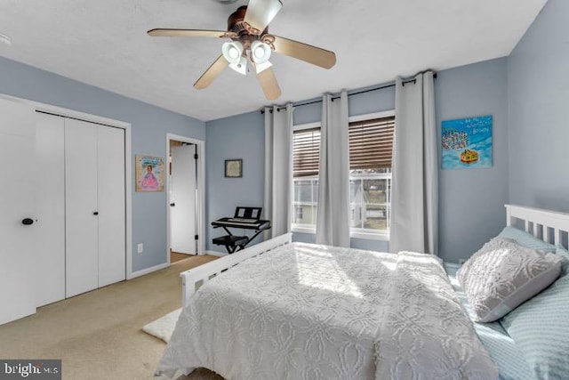 bedroom featuring light colored carpet, ceiling fan, and a closet