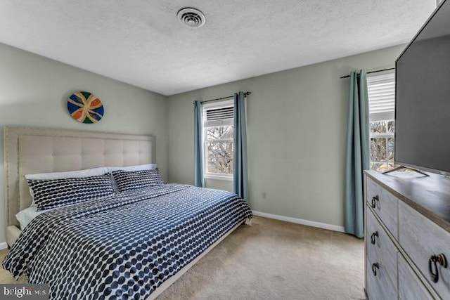 bedroom with light colored carpet and a textured ceiling