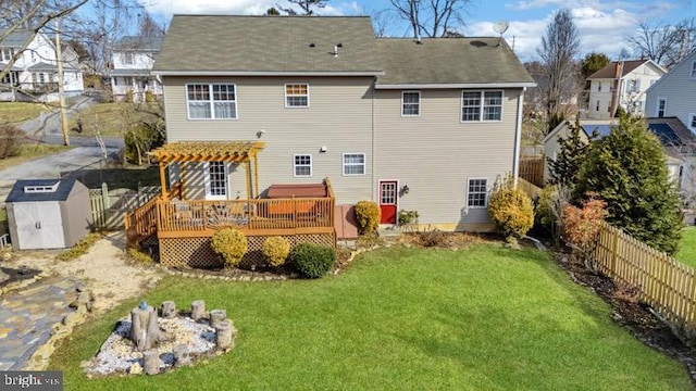 back of house with a wooden deck, a pergola, a lawn, and a storage unit