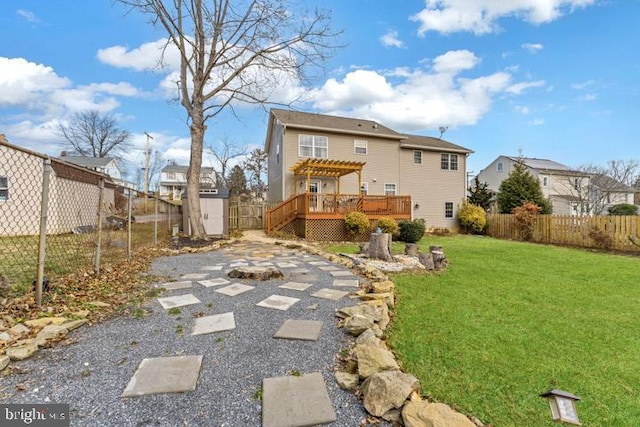 back of property with a wooden deck, a yard, a pergola, and a storage unit