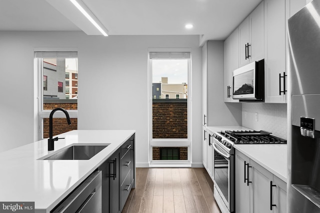 kitchen featuring white cabinetry, sink, a wealth of natural light, and appliances with stainless steel finishes