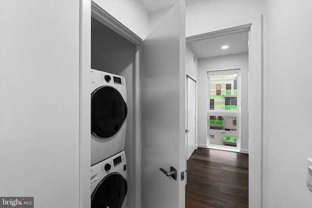 clothes washing area featuring stacked washer / dryer and dark hardwood / wood-style floors