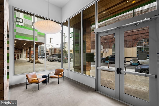 doorway to outside with concrete flooring, french doors, and a healthy amount of sunlight