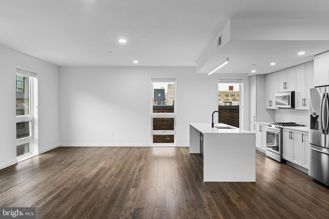 kitchen featuring white cabinetry, appliances with stainless steel finishes, sink, and a kitchen island with sink