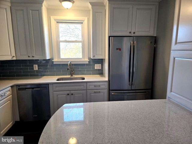 kitchen featuring white cabinetry, black dishwasher, sink, stainless steel fridge, and decorative backsplash