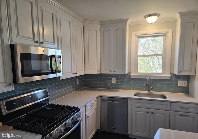 kitchen with white cabinetry, appliances with stainless steel finishes, sink, and backsplash