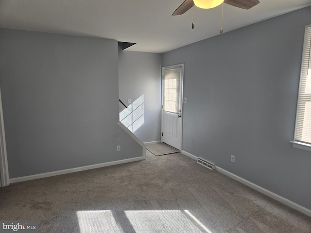 carpeted spare room with ceiling fan