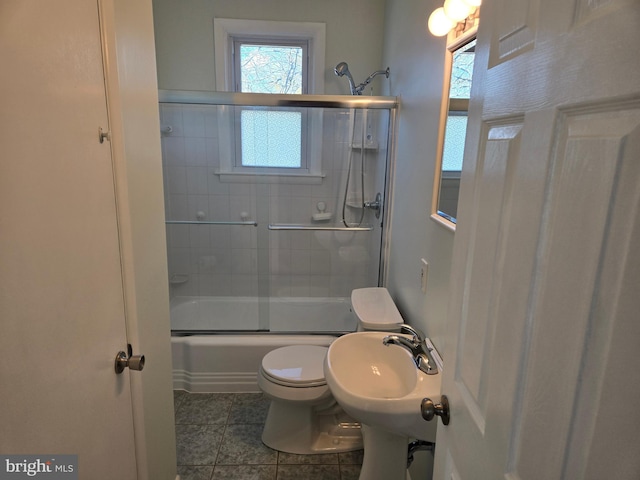 full bathroom featuring tile patterned flooring, sink, shower / bath combination with glass door, and toilet