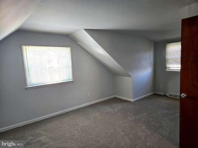 bonus room with lofted ceiling, dark carpet, and a baseboard heating unit