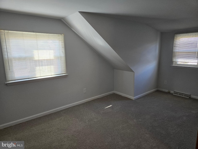 bonus room with lofted ceiling and dark carpet