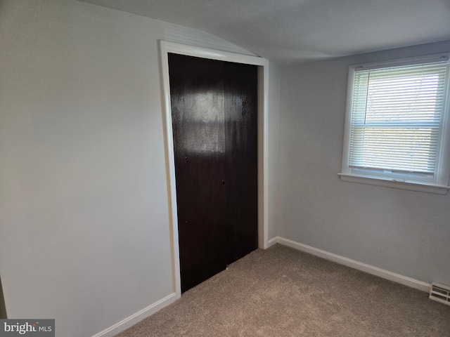 unfurnished bedroom featuring carpet and a closet