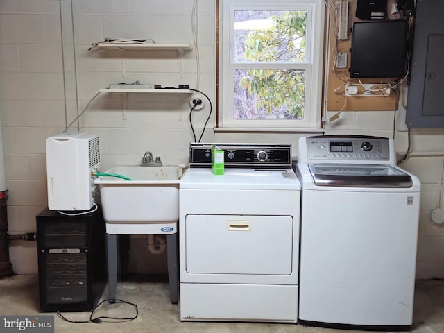 washroom with sink, electric panel, and independent washer and dryer