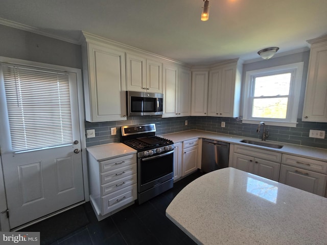 kitchen with backsplash, stainless steel appliances, sink, and white cabinets