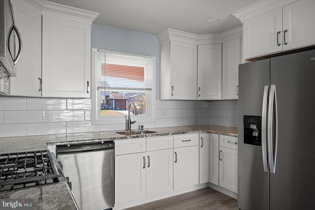 kitchen with stainless steel appliances, white cabinetry, and sink