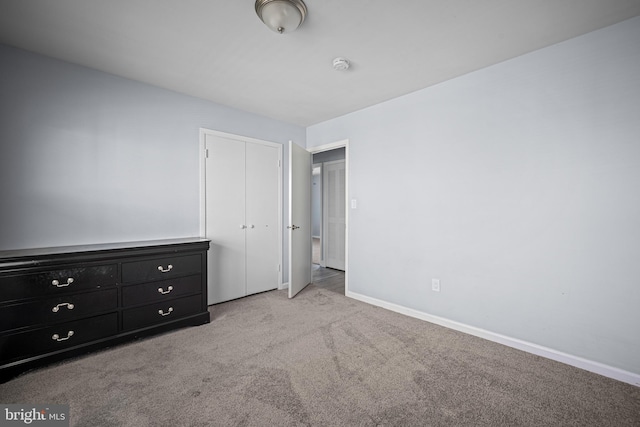 unfurnished bedroom featuring a closet and light carpet