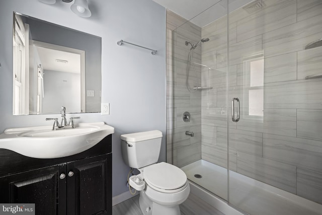 bathroom featuring vanity, an enclosed shower, and toilet